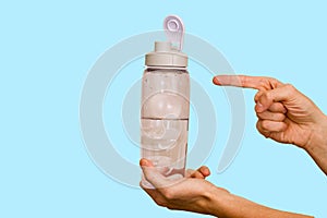 Water bottle in hand on blue background