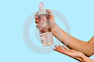 Water bottle in hand on blue background