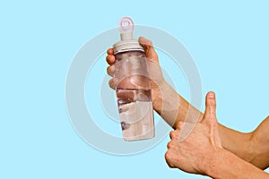 Water bottle in hand on blue background