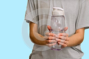 Water bottle in hand on blue background