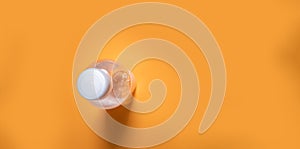 Water bottle on orange background with copy space. Simplicity