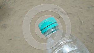 Water bottle with sand background.