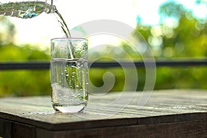 Water from the bottle was poured into a glass placed on the table.