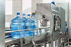 Water bottling conveyor line with plastic bottles or gallons on water factory production