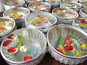 Water in bowl mixed with perfume and vivid flowers corolla for Songkran festival in Thailand