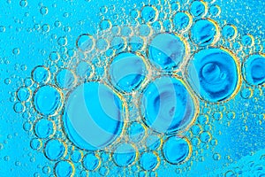 Water bubbles on blue and yellow background. Scientific image of cell membrane. Macro up of liquid substances. Abstract molecule a