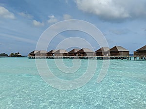 Water bungalows turquoise lagoon Maldives island sunny day background wallpaper