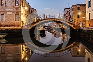 Water canal,bridge at dusk,Venice,Italy.Typical boat transportation,Venetian travel urban scene.Water transport.Popular tourist