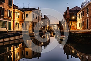 Water canal at dusk,Venice,Italy.Typical boat transportation,Venetian travel urban scene.Water transport.Popular tourist