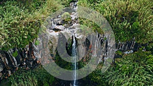 Water cascade flowing high cliffs aerial view. Cold stream rushing down nature