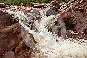 Water cascade on a small river with brown stones. Nature landscape. West of Ireland. Connemara