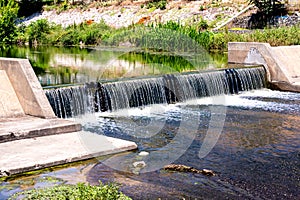 Water cascade streaming down from small dam, water saving ecology concept