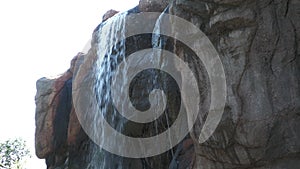 Water cascades down from the top of a big rock