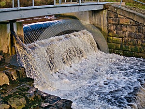 Water cascades over a water management weir on the River Whitendale in Lancashire, northern England.