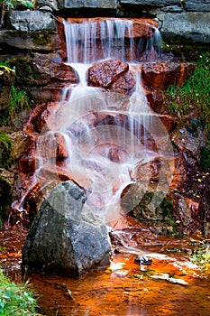 Water Cascading Over Red Algae Covered Rocks