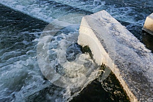 Water Cascading over Weir Step in river canal.