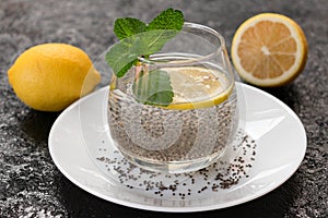 Water with chia seeds and lemon on a black background. A useful drink for weight loss.