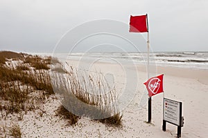 Water closed to public flag on stormy ocean beach