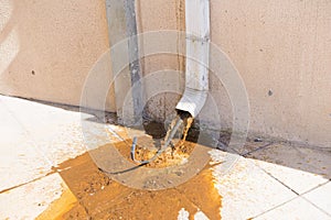 Water contaminated with rust and sand flowing from a building\'s stormwater