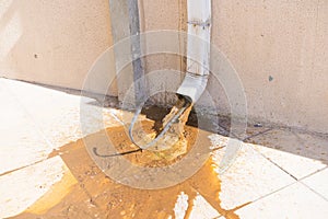 Water contaminated with rust and sand flowing from a building\'s stormwater