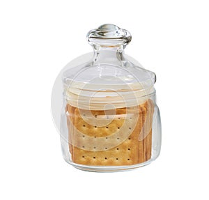 Water crackers square shape in a clear glass jar, isolated on white background. Glass jar with saltine or square soda crackers photo