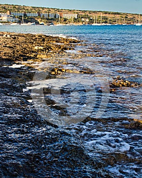 Water crashing on the shoreline at Mellieha Bay