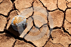 Water Crisis, Climate Change, El Nino, Global Warming Issue Concept. Brown Globe lay on Cracked Dry Soil Ground. Land without photo