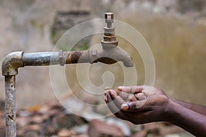 Water crisis is a serious threat to India and worldwide,a man holding his hand under the tap for water