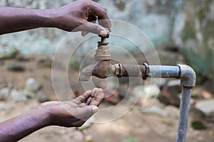 Water crisis is a serious threat to India and worldwide,a man holding his hand under the tap for water