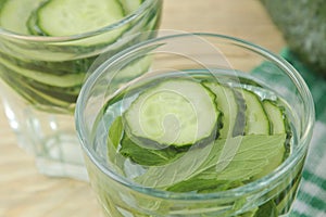 Water with cucumber. Refreshing diet water with cucumber and mint in a glass beaker on a wooden background. detox drink concept. s