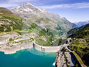 Water dam and reservoir lake aerial view in Alps mountains generating hydroelectricity. Low CO2 footprint, decarbonize, renewable photo