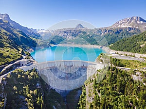 Water dam and reservoir lake aerial view in Alps mountains in summer generating hydroelectricity. Low CO2 footprint, decarbonize, photo