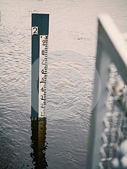 Water depth measuring pole in a river to gauge high or low level of water, Vertical image. Nature environment monitor concept