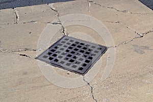 A Water Drain on Cracked Concrete. Metallic. Metals. photo