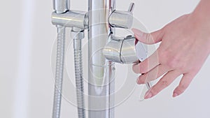 Water dripping to stop running as hand turn off the faucet. Save the water concept. Detect a Leak week. hand close water