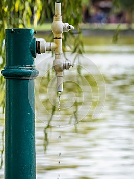 Water dripping from a water tap. Drop of water close up with a blurred water background