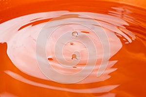 Water drop falling and drips in colored glass