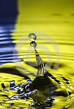 Water drop falling in to a pool of water