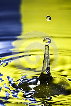 Water drop falling in to a pool of water