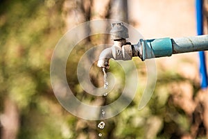 Water drop flowing from faucet