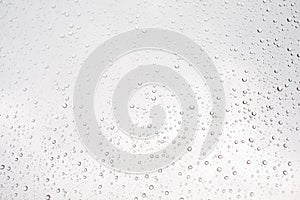 Water drop on glass window with cloudy sky on background
