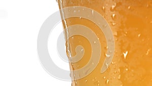 Water drop gliding on cool glass with lager beer, extremely closeup, slow motion in white background