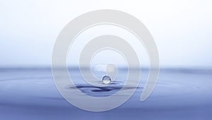 Water drop splash in a glass blue colored