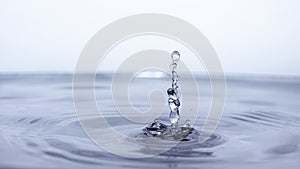 Water drop splash in a glass blue colored