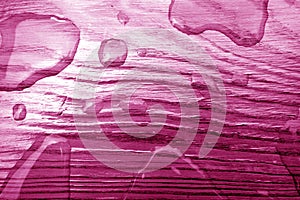 Water drop on wooden surface in pink tone