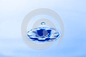 Water droplet falling impact with water surface. causing rings on water surface