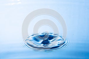 Water droplet falling impact with water surface. causing rings on water surface