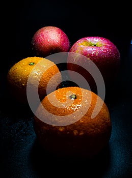 Water droplet on glossy surface of freshness orange and red apple