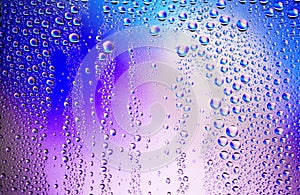 Water droplets condense on the colorful glass surface