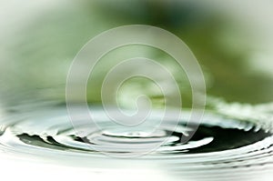 Water Droplets Falling Into A Pond Creating Ripples